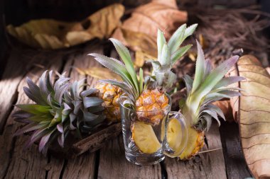Ananas dilimleri ve eski ahşap arka plan üzerinde kabuklu ananas