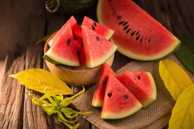 Karpuz dilimleri rustik ahşap zemin üzerine ahşap kase.