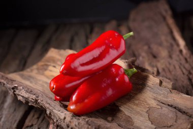 Ahşap siyah zemin üzerine kırmızı biber soğuk. Kırmızı sıcak biber pepp