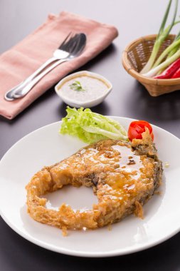 Beyaz tabakta derin kızarmış balık balık sosu ile