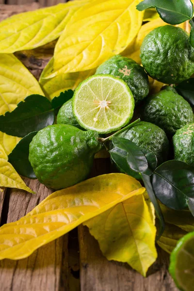 Čerstvý bergamot a žluté listy na staré dřevěné stoly pozadí — Stock fotografie