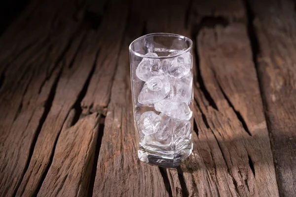 Is i ett glas på trä bakgrund. — Stockfoto