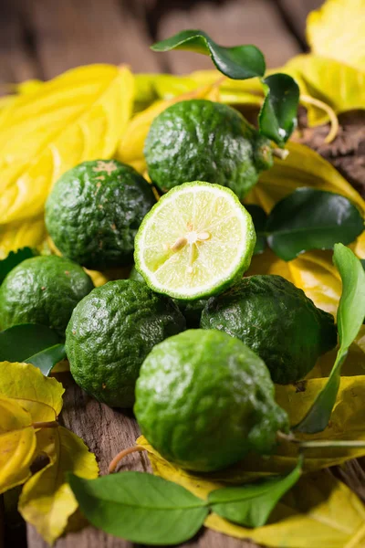 Čerstvý bergamot a žluté listy na staré dřevěné stoly pozadí — Stock fotografie