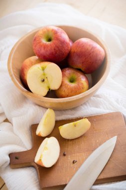 Ahşap arka plan üzerinde beyaz kumaş üzerine kırmızı elmalar