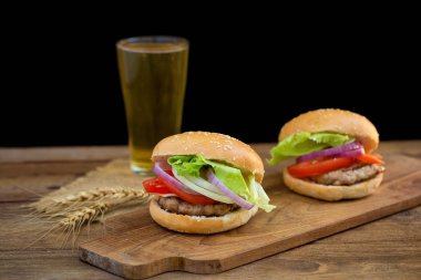 Peynirli hamburger ızgara et, peynir, domates Ahşap yüzeyi ile