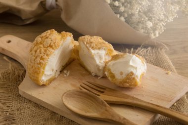 Ahşap tahta üzerinde hizmet vanilya ve süt muhallebi krem puffs dolu