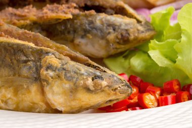 Beyaz arka plan üzerinde balık yağda kızarmış levrek.