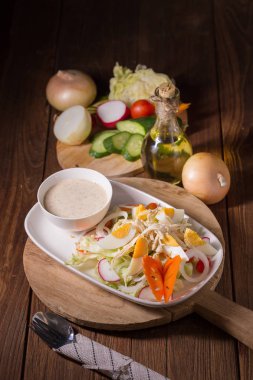 Beyaz tabakta tavuk ve haşlanmış yumurta taze yeşil salata