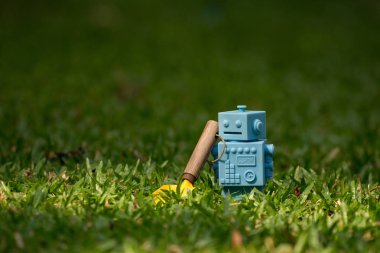 Mavi Retro robot oyuncaklar Bahçe aletleri doğal yeşil yaprakları ile 