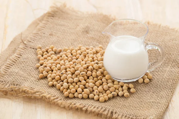Soya sütü ve soya fasulyesi ile soyut bulanık ormanının ahşap Kupası