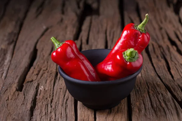 Red chilly pepper on wooden black background. Red hot chili pepp