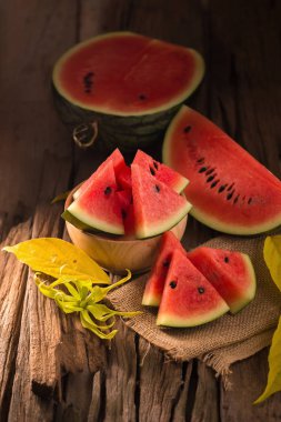 Karpuz dilimleri rustik ahşap zemin üzerine ahşap kase.