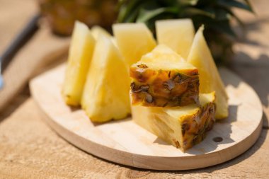Ananas dilimleri ve eski ahşap arka plan üzerinde kabuklu ananas