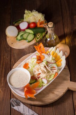 Beyaz tabakta tavuk ve haşlanmış yumurta taze yeşil salata