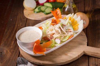 Beyaz tabakta tavuk ve haşlanmış yumurta taze yeşil salata