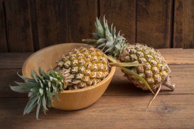 Ahşap arka plan üzerinde olgunlaşmış taze ananas