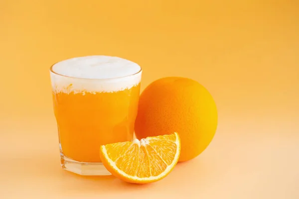 Copo de Orange Smoothie recentemente espremido em um backgroun laranja — Fotografia de Stock