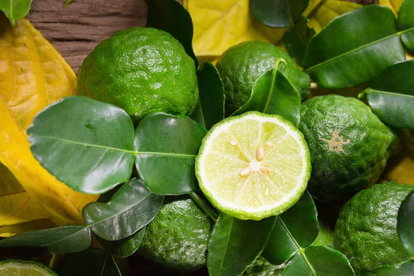 Čerstvý bergamot a žluté listy na staré dřevěné stoly pozadí — Stock fotografie