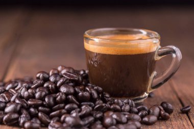 Kahve fincanı kavrulmuş kahve çekirdekleri ahşap arka plan üzerinde ile