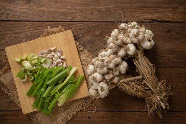 Taze kereviz kıyılmış ve sarımsak ahşap kesme tahtası ve ahşap arka plan