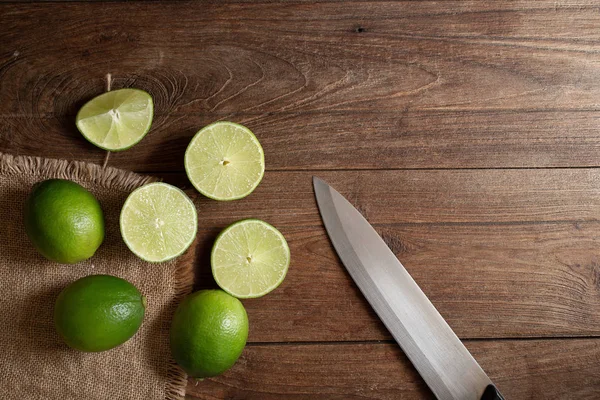 Taze limon dilimleri ile kahverengi ahşap masa üzerinde bıçak