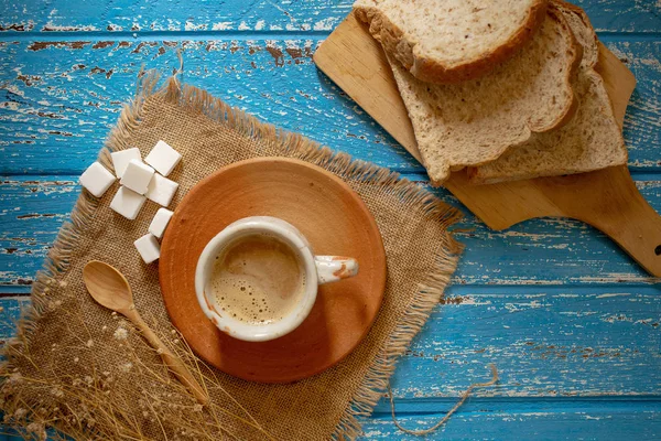 Sıcak kahve ile mavi ahşap masa ekmek dilimleri