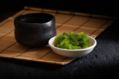 Koyu arka plan üzerinde oval deniz üzüm deniz yosunu