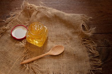 Turuncu jam çul üzerinde tahta kaşıkla kare şişe 