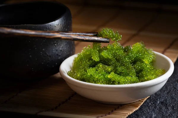 Koyu arka plan üzerinde oval deniz üzüm deniz yosunu