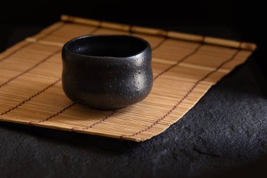 Bambu forması koyu arka plan üzerinde siyah çay Kupası.