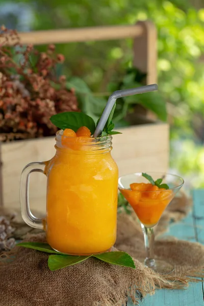 木桌上的罐子玻璃上的健康橙汁奶昔 — 图库照片