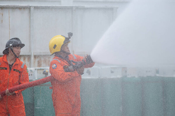 Firefighters spraying water in LPG gas tanks