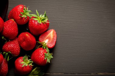 Koyu ahşap arka planda olgun kırmızı çilekler..