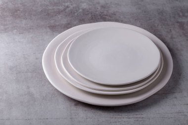 Çimento tahtasına boş beyaz seramik tabak.