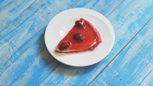 皿の上で回転するイチゴチーズケーキのクローズアップショット — ストック動画