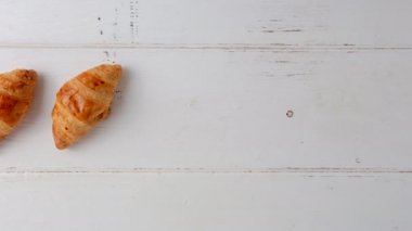Beyaz ahşap arka planda taze pişmiş kruvasan Motion stop