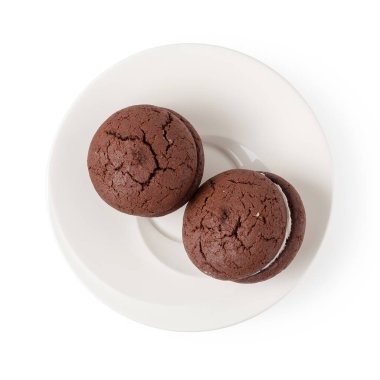 Beyaz arka planda izole edilmiş beyaz bir tabakta çikolatalı kurabiye ve krema.