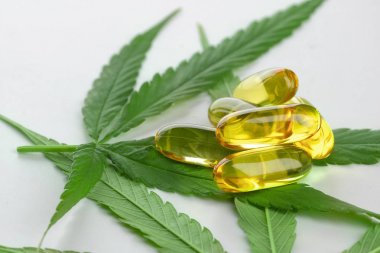 Beyaz arka planda esrar esansiyel yağı Kapsüller.