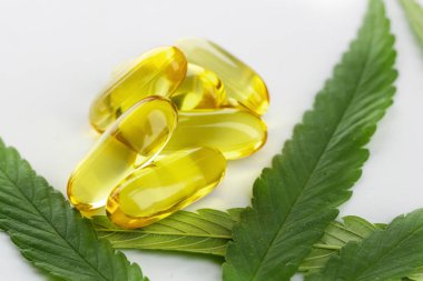 Beyaz arka planda esrar esansiyel yağı Kapsüller.