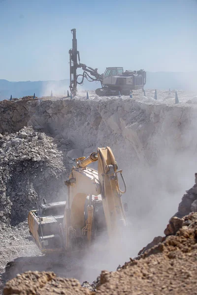 Gele graafmachine vult een dump truck met rotsen op kolenmijn — Stockfoto