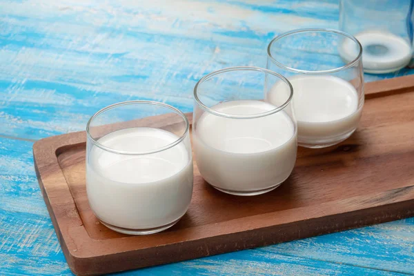 青い木製のテーブルの上にミルクとミルクのグラスのボトル, healt — ストック写真