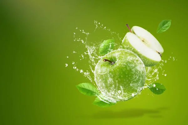 Wasser spritzt auf frischem grünen Apfel auf grünem Hintergrund — Stockfoto