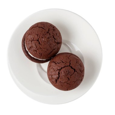 Beyaz arka planda izole edilmiş beyaz bir tabakta çikolatalı kurabiye ve krema.