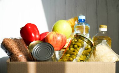 Çeşitli yiyeceklerle birlikte bağış kutusu. Tereyağı, konserve, mısır gevreği ve meyveli karton kutuyu aç.