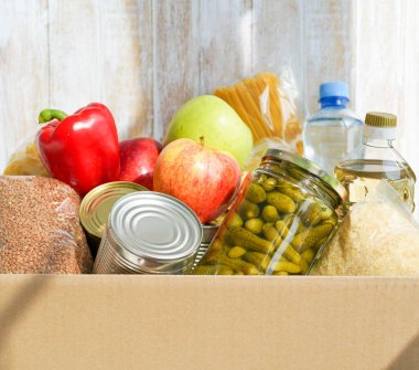 Çeşitli yiyeceklerle birlikte bağış kutusu. Tereyağı, konserve, mısır gevreği ve meyveli karton kutuyu aç.