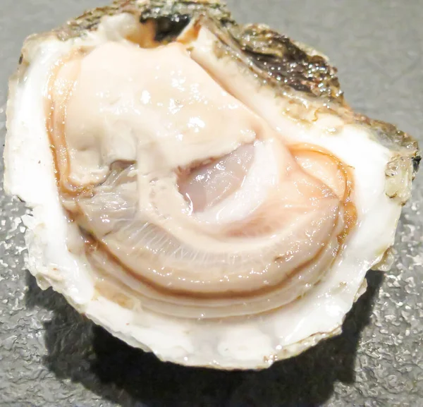 新鲜的牡蛎在一道菜上 与牡蛎 柠檬和冰块一起食用 健康的海鲜 在餐馆里吃牡蛎大餐和香槟 食糖食品 — 图库照片