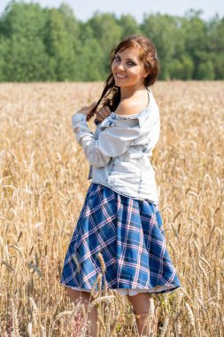 Güneşin altındaki buğday tarlasında güzel esmer kadın