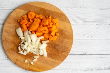 Tahta bir masada doğranmış soğan ve havuç..