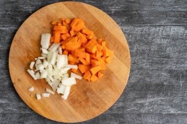 Tahta bir masada doğranmış soğan ve havuç..
