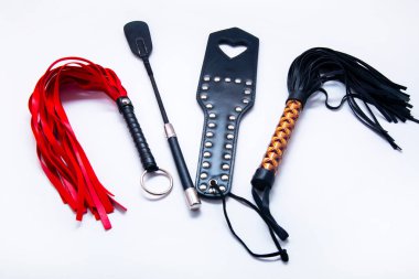 Beyaz arka planda kırbaç. Yetişkinlerin cinsel oyunları için aksesuarlar. BDSM için oyuncaklar, şaplak cihazları. Şaplak ve ceza konsepti. Köle Spank Paddle, bdsm, yetişkin kırbaçları. kopyalama alanı. bdsm için ayarla